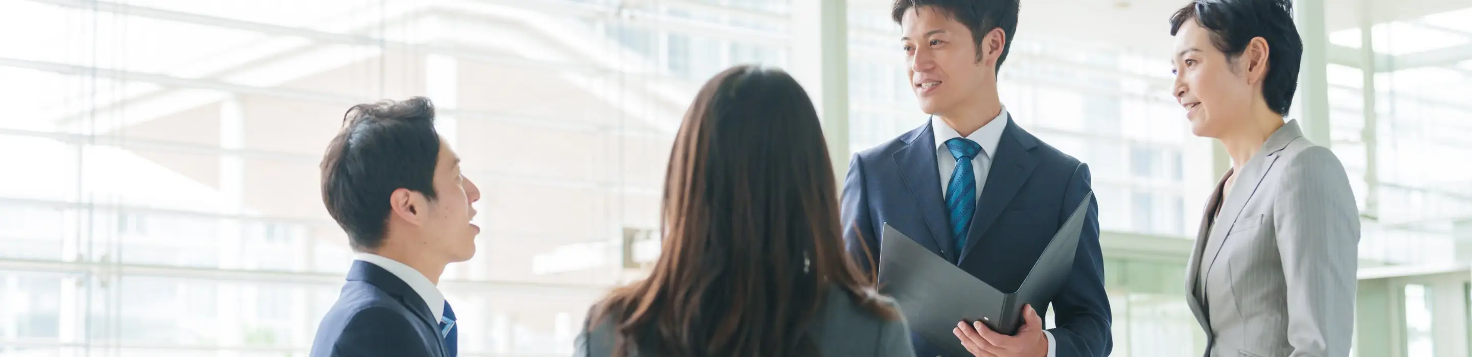 MOMENTUMのロゴが表示されたプレゼンテーション画面を指差す男性と、それを見る人物