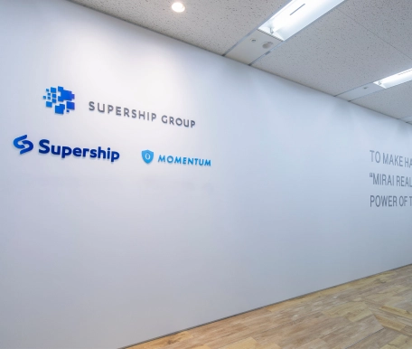 グループ企業ロゴとミッションステートメントが描かれたオフィス壁面